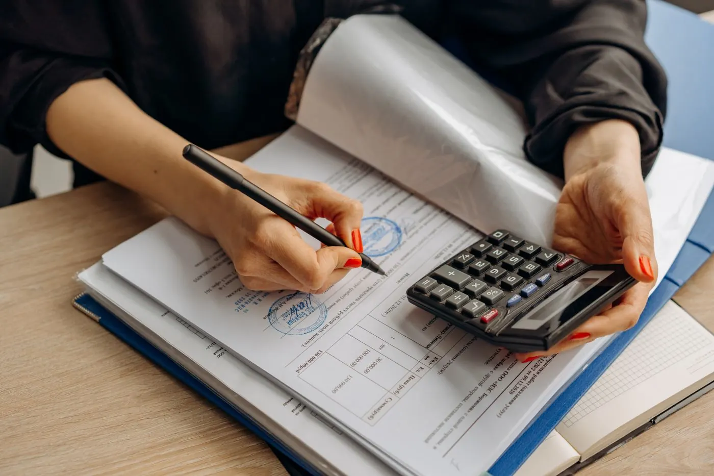 Printed business purchase agreement on a desk beside a pen and a calculator