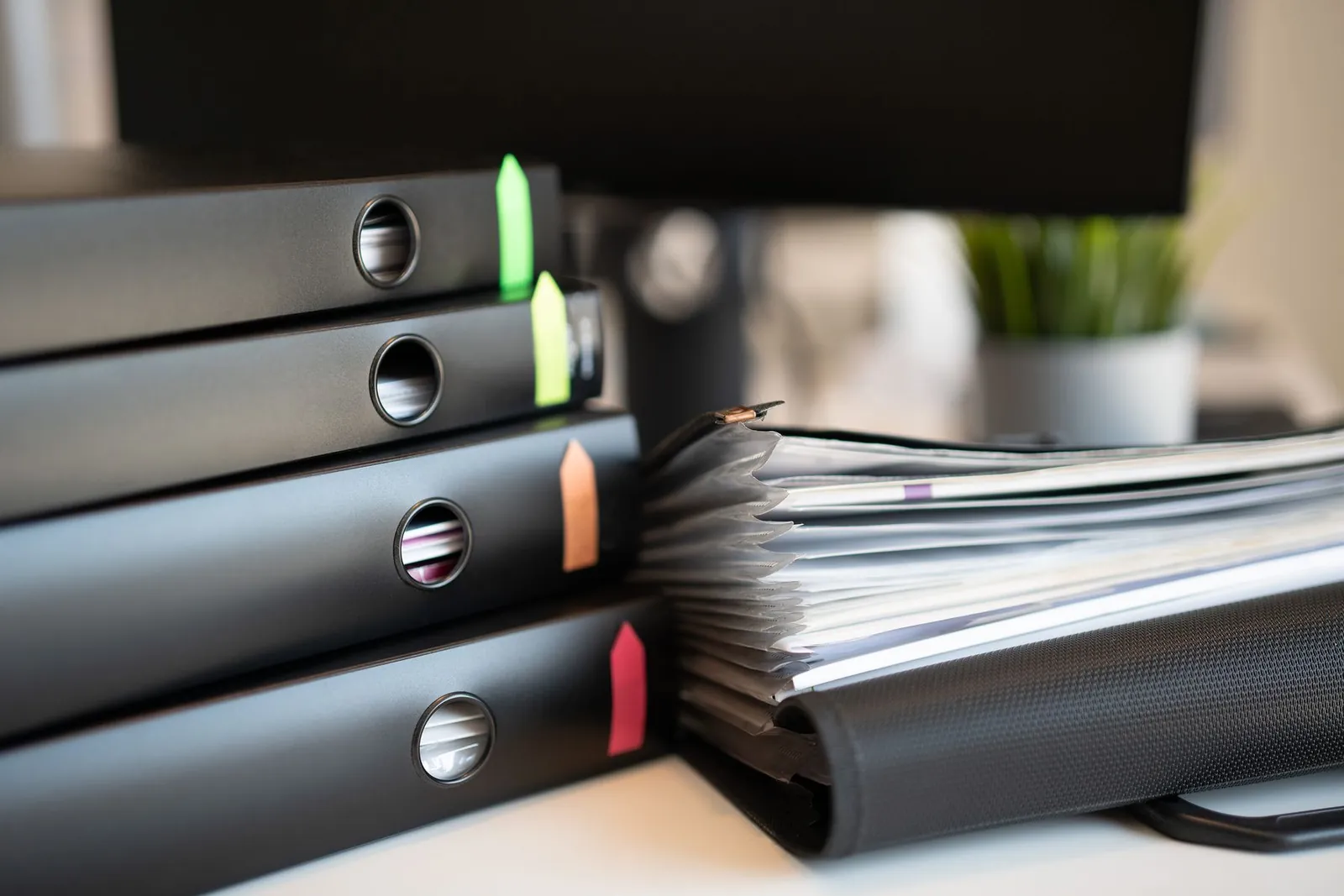 File binders with colored tabs stacked on an office desk