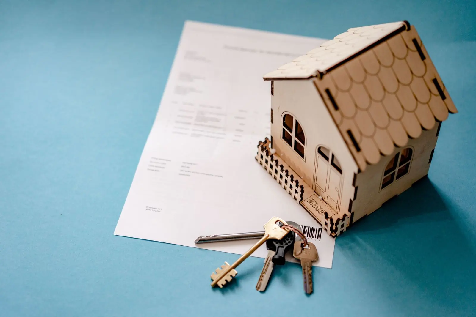 Set of keys resting on signed closing documents on a wooden table