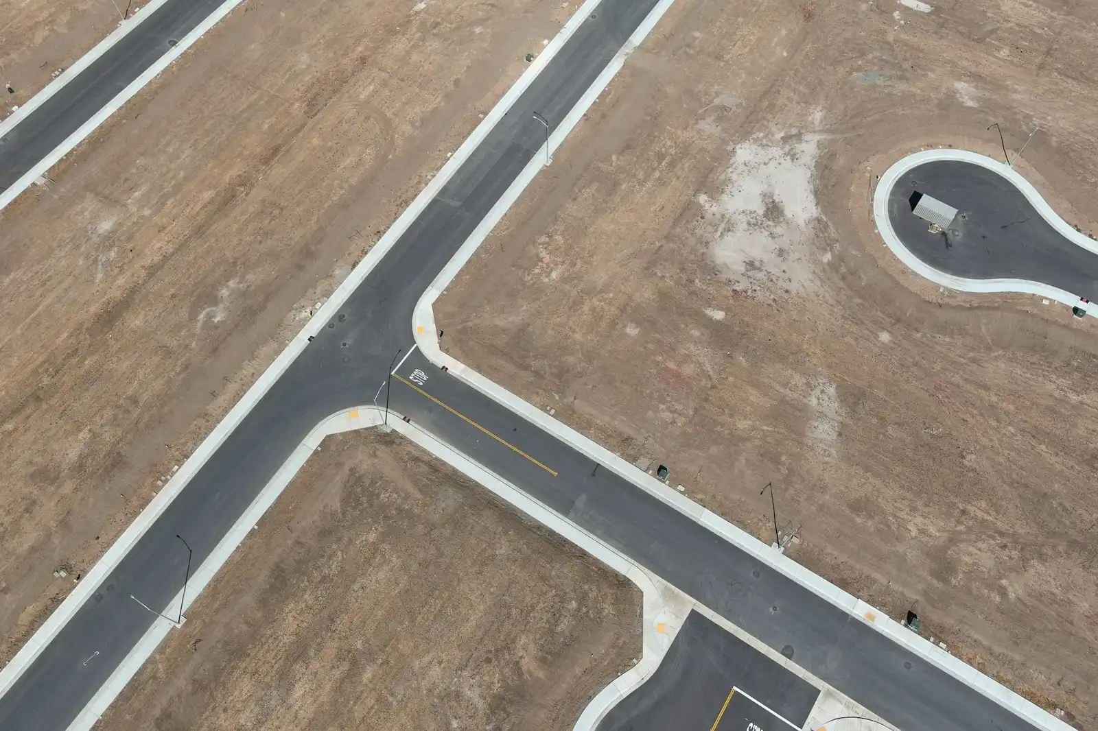Aerial view of two roads crossing in dry desert terrain