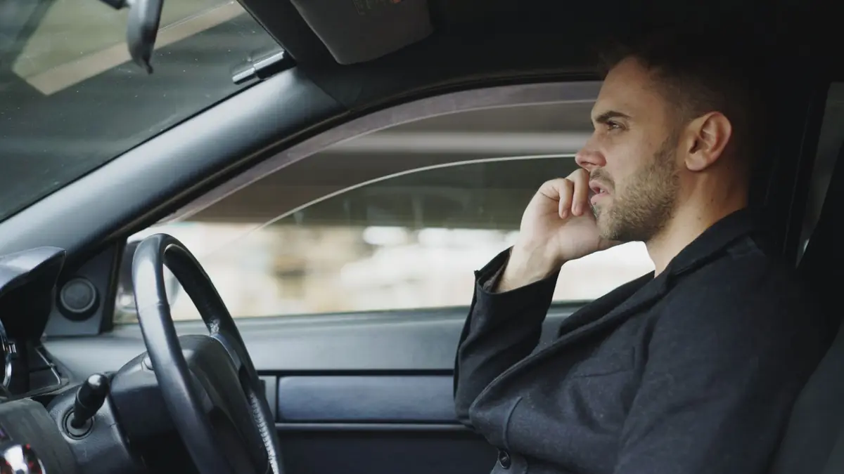 Driver on a phone call with an insurance adjuster from his car