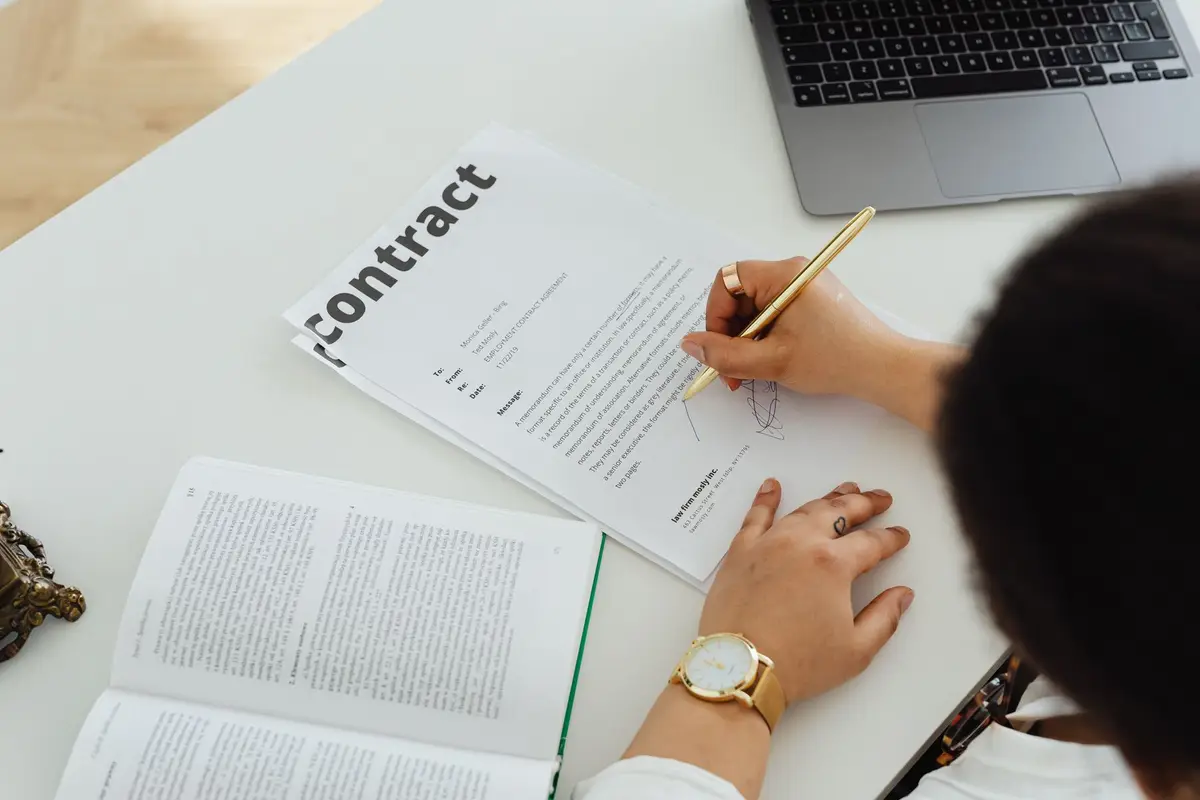 Person signing a settlement release form at a desk