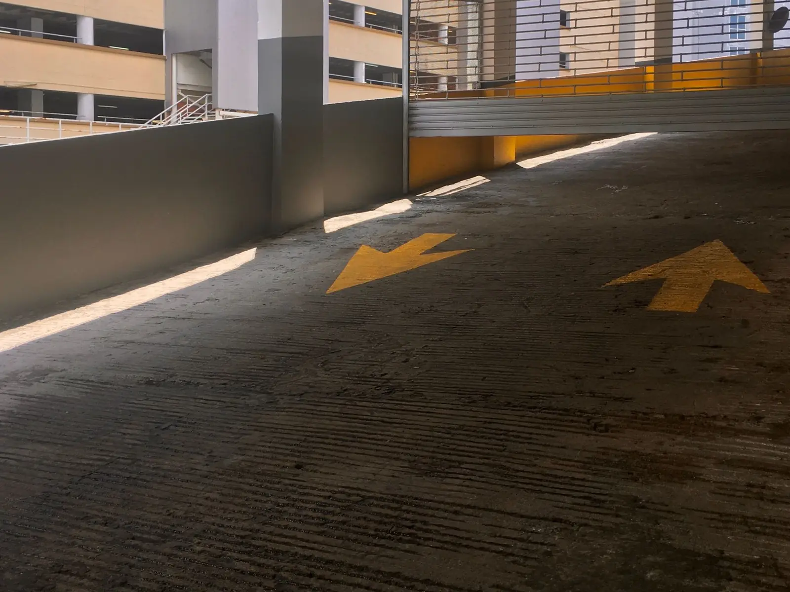 Empty parking garage ramp with painted directional arrows