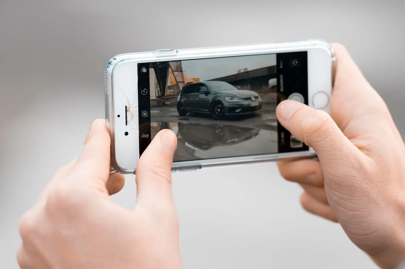 Hands holding a phone beside the side of a car